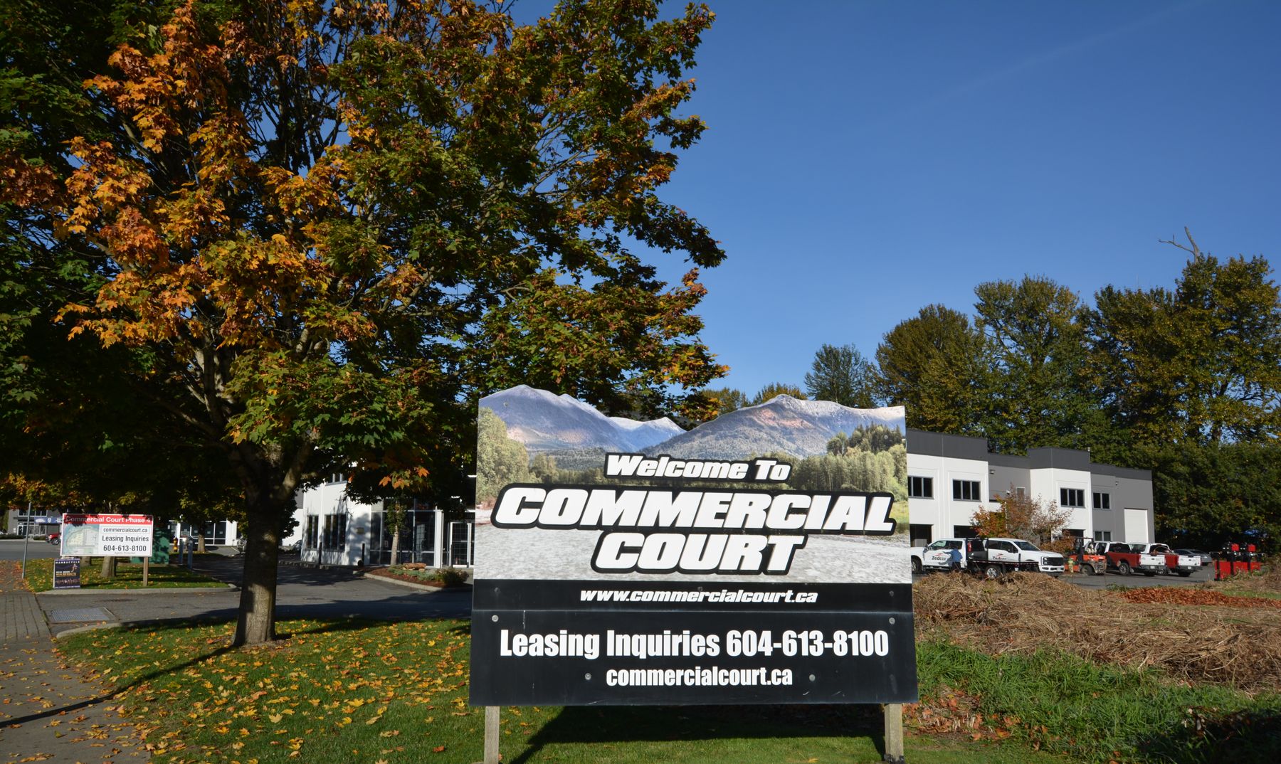 Welcome to Commercial Court entrance sign beside the parking area, with the leasing phone number and website